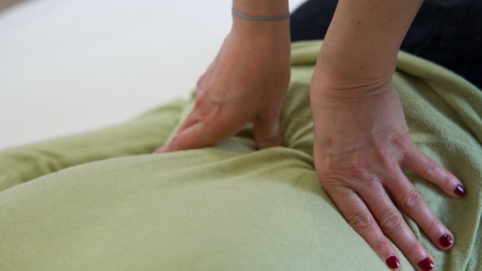 Pressions du shiatsu — mains de Solène Canivet sur le bas du dos d'une cliente